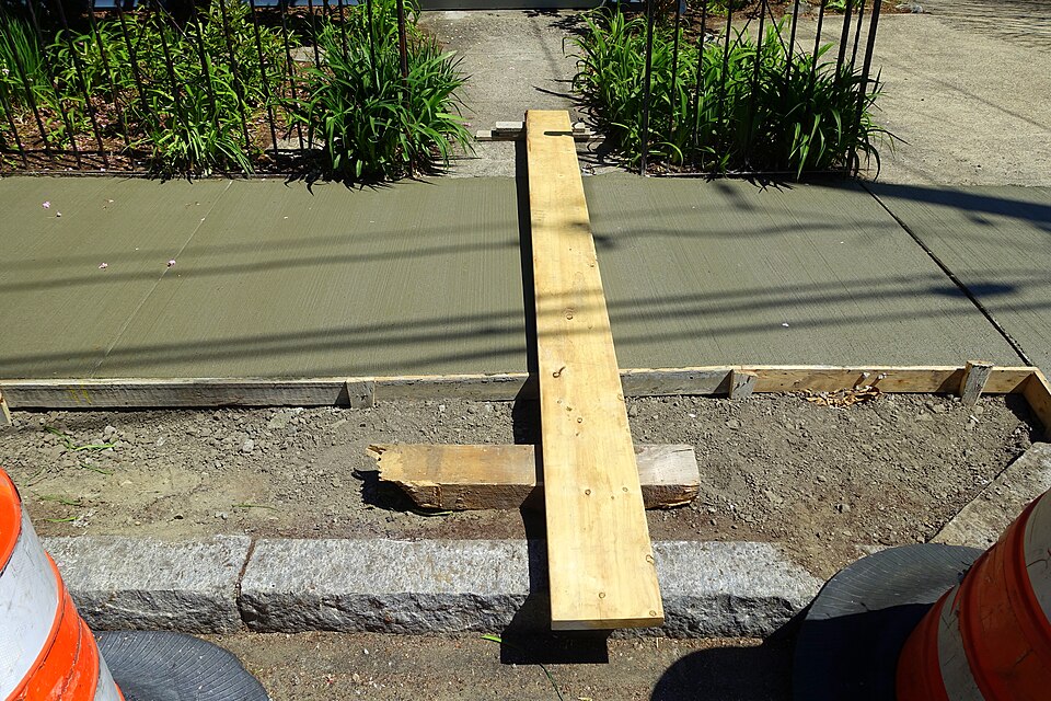 Sidewalk concrete being formed and prepared on a work site.